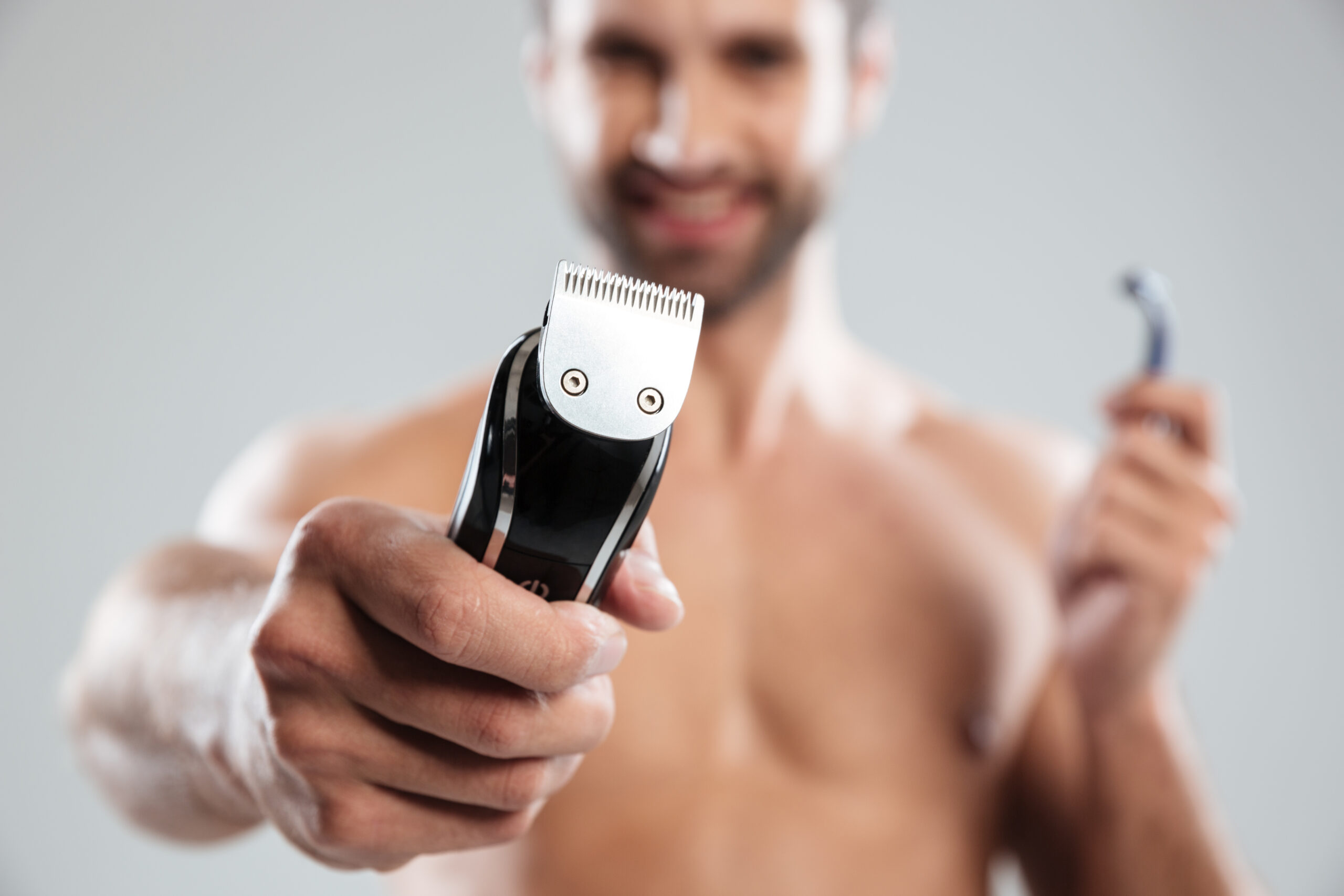 Um homem apontando o melhor depilador masculino para a câmera.