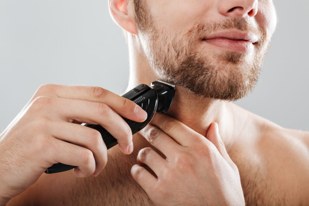 Um homem raspando a barba com o melhor depilador masculino.